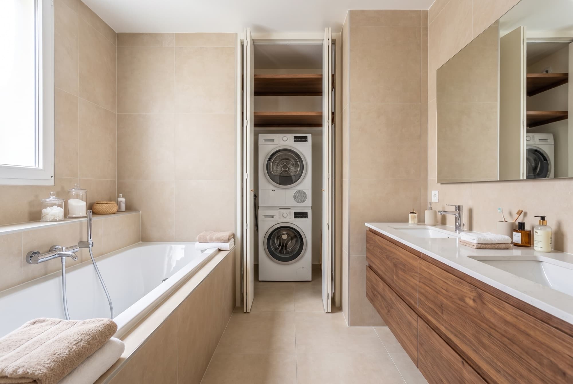 A23's family bathroom, full-size bathtub, walnut double vanity and a concealed washer-dryer cupboard